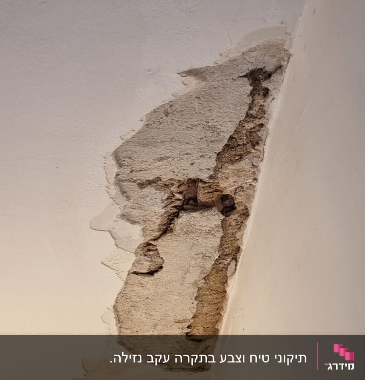 קיר עם טיח מתקלף וחור בתקרה